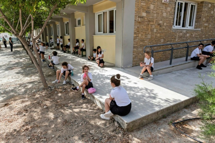 Cypriot children make a brave effort of keeping up social distancing in the school yard on their first day back in  class