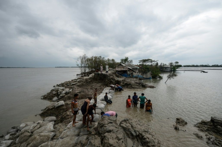 Volunteers and residents work to repair a damaged dam following the landfall of Cyclone Amphan in Burigoalini, Bangladesh, on May 21, 2020