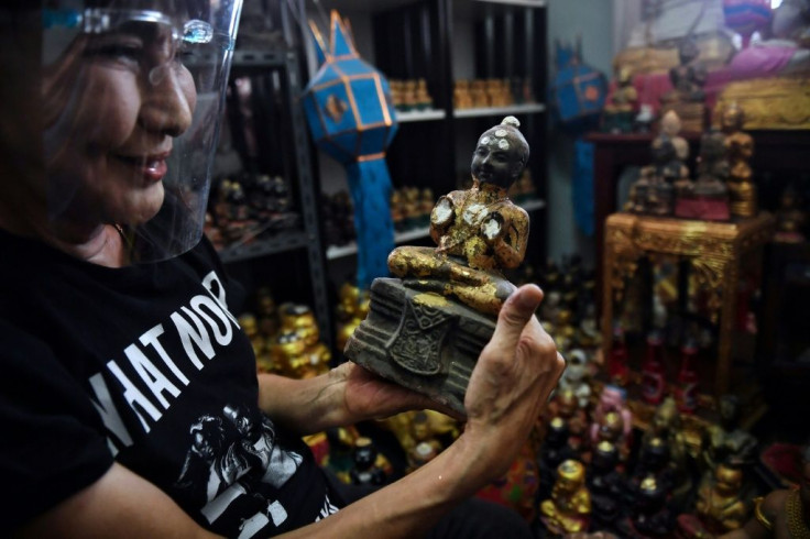 'Golden Son' collector Wanchai Pongsompetch holds one of the figurines in her home north of Bangkok