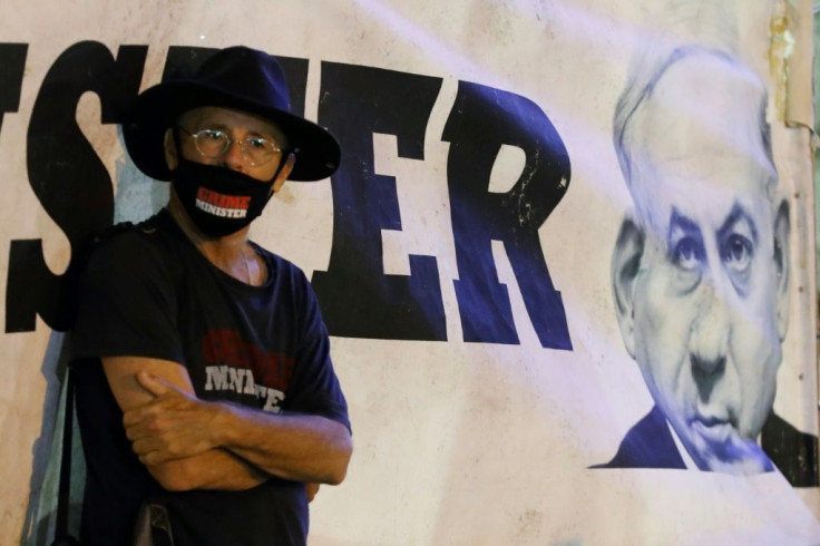 An Israeli protester, wearing a protective mask bearing the slogan "Crime Minister", takes part in a demonstration against Netanyahu in Tel Aviv earlier this month