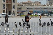 A masked man checks his phone in Qatar where residents and citizens have been required by law to install a coronavirus contact tracing app on their handsets since Friday