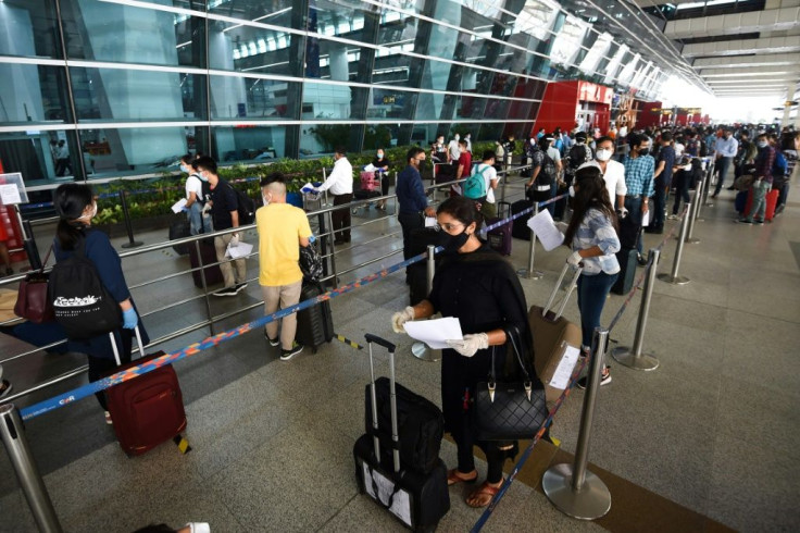 At New Delhi airport, hundreds of people anxious to get home but apprehensive about the risks queued from before dawn