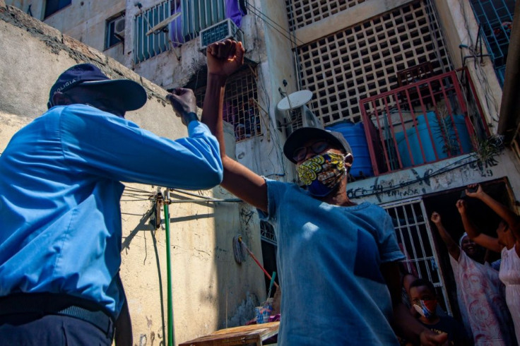 A Luanda resident celebrates with a policeman after the Angolan National Director of Public Health lifted a two week virus quarantine order