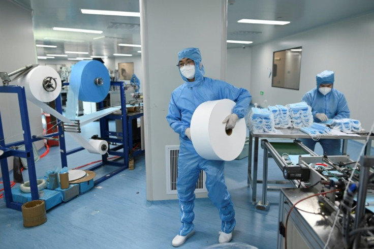 A worker wearing a protective suit makes masks at Naton Medical Group in Beijing