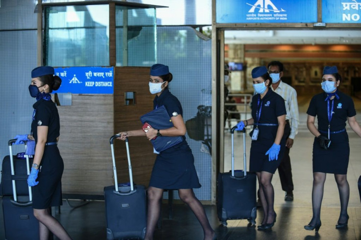 Flight attendants walk out of Sardar Vallabhbhai Patel International Airport in Ahmedabad as domestic flights resume after the government eased some of its virus lockdown restrictions