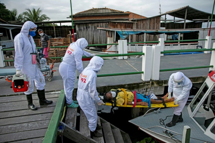Health personnel carry coronavirus-infected Brazilian Eladio Lopes, 79, on a stretcher to be transferred on an ambulance boat from the community of Portel to a hospital in Breves, on Marajo island in Para state
