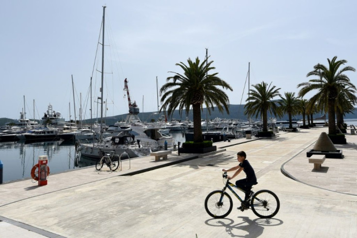 A solitary cyclist rides at the eerily quiet Porto Montenegro marina