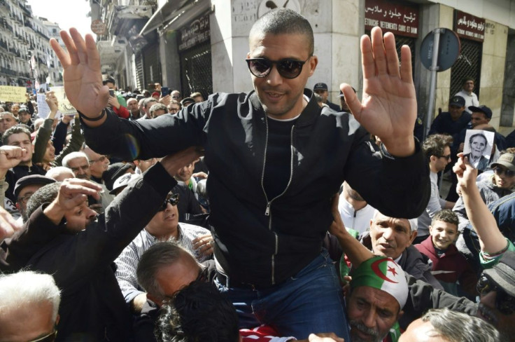 Algerian protesters carry journalist Khaled Drareni, who was arrested while covering an anti-government protest and was accused of "inciting an unarmed gathering and damaging national integrity," on their shoulders on March 6, 2020 in Algiers