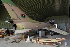 Fighters loyal to Libya's UN-recognised Government of National Accord (GNA) climb over a partially disassembled MiG 23 aircraft, after seizing Al-Watiya airbase  southwest of the capital Tripoli, on May 18, 2020.