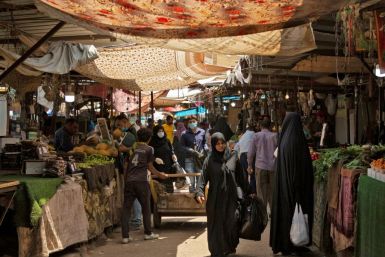 Iraqis walk through a fresh produce market in the southern Iraqi city of Basra as some lockdown restrictions imposed during the novel coronavirus pandemic have been eased