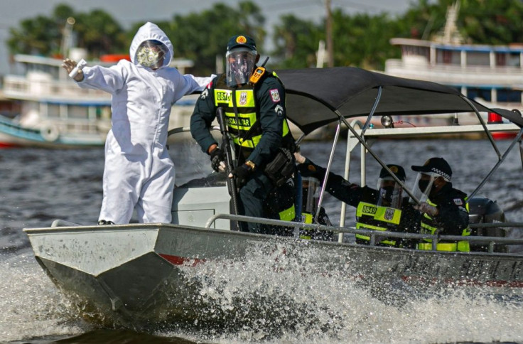 A government medical worker, in a joint operation with military police, prepares to check passengers on boats in the Melgaco bay, Brazil