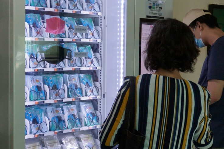 Residents get free face masks from a vending machine by scanning their identification card, set up by the government as part of the effort to halt the spread of the COVID-19 in Singapore