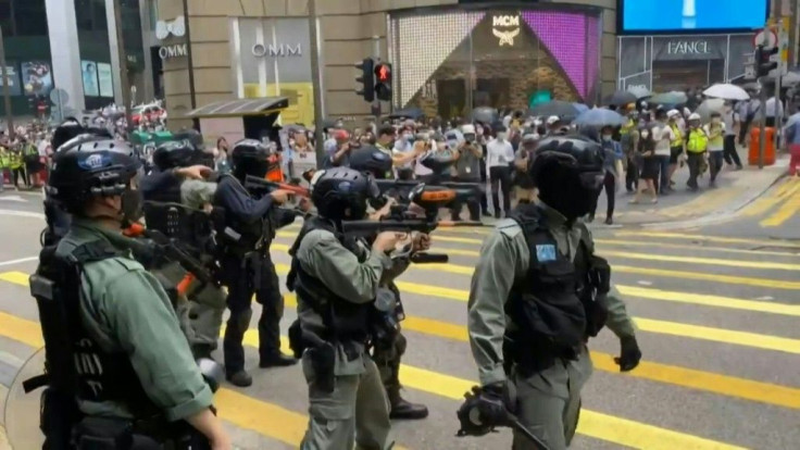 Riot police in Hong Kong fire pepper-ball rounds in the central  commercial district as they try to stamp out protests against a bill banning insults to China's national anthem.