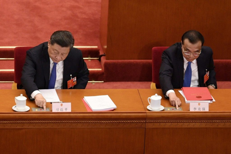 China's President Xi Jinping (left) and Premier Li Keqiang vote on a proposal to draft a Hong Kong security law during the closing session of the National People's Congress at the Great Hall of the People in Beijing