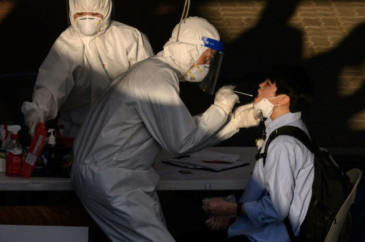 A South Korean health worker tests a man at a temporary COVID-19 testing centre in Bucheon, south of Seoul -- the country is reimposing some lockdown measures after a spate of new infections cropped up
