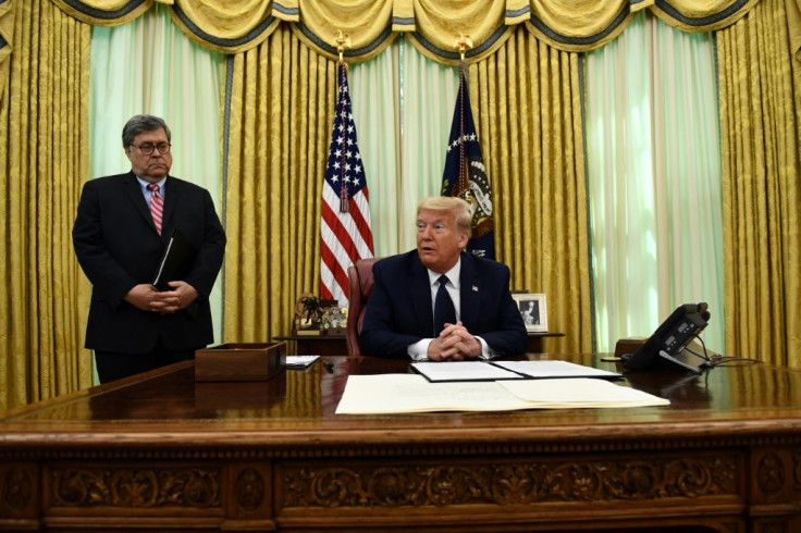 US President Donald Trump, flanked by Attorney General William Barr, prepares to sign an executive order on social media companies in the Oval Office on May, 28, 2020