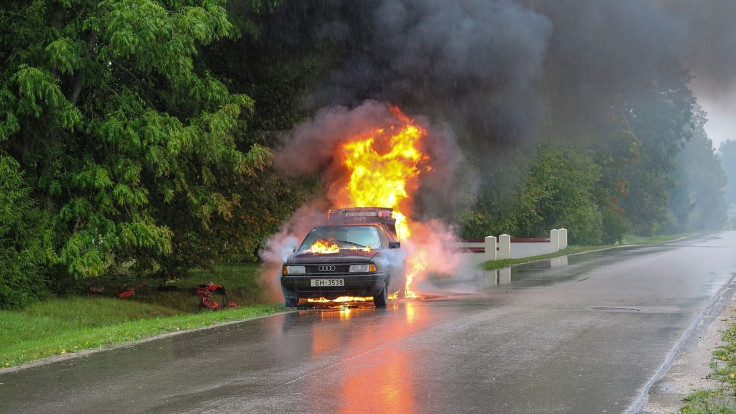 man drags driver away from burning car