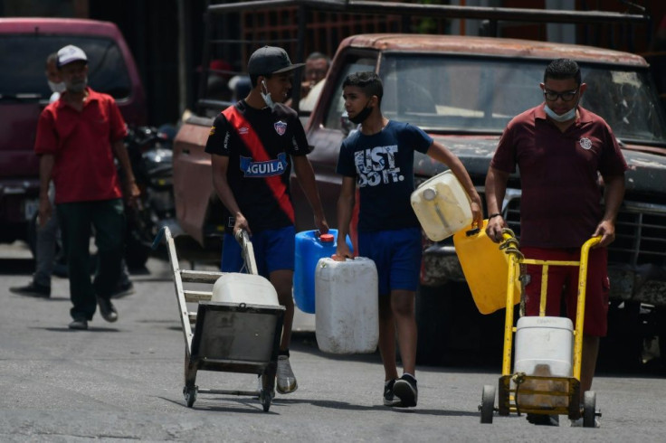 A man carries water in Caracas May 19, 2020 amid the coronavirus pandemic