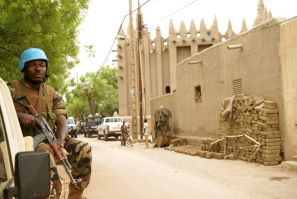 A UN peacekeeper patrols outside the mosque in Mopti, central Mali: two members of the peacekeeping mission have died of coronavirus, the organisation said