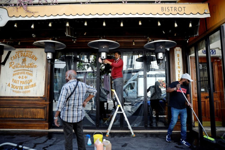 Employees clean the terrace of a Paris cafe ahead of reopening in early June 2020