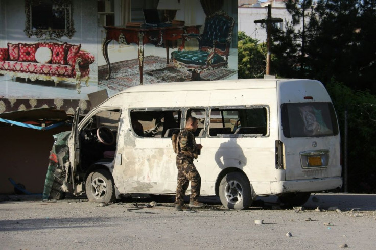 A member of the Afghan security forces investigates a damaged vehicle that had been carrying employees of Khurshid TV when it was targeted by a bomb in Kabul on May 30,2020 A roadside bomb killed a television journalist in Kabul on May 30, soon after a to