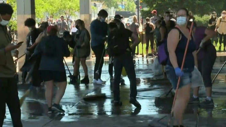 People help clean up bank and businesses in Minneapolis after a fresh night of violence sparked by the death of George Floyd in police hands overwhelmed law enforcement