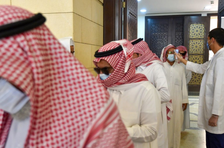 A Saudi medical worker checks the temperatures of worshippers upon their arrival at Al-Rajhi mosque on Sunday