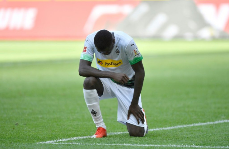 Moenchengladbach's French forward Marcus Thuram  took a knee after scoring