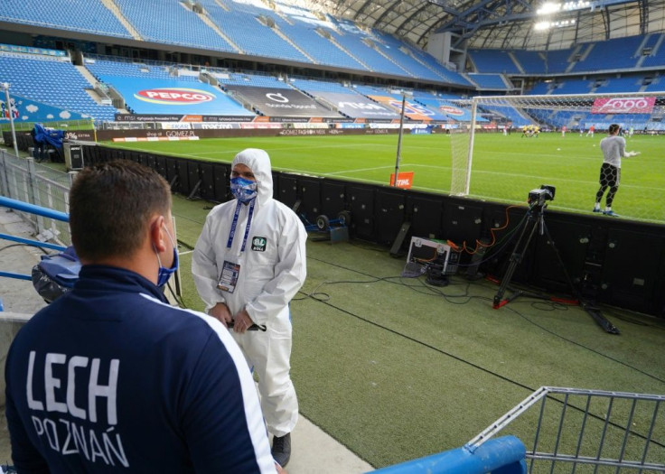 A man in a protective suit keeps watch before the game between Lech Poznan and Legia Warsaw