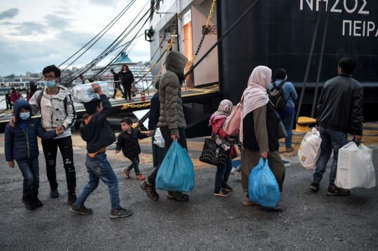 Shelters on the islands have hosted five times their intended capacity of some 6,000 people. Here refugees wait for a bus after being transferred to the mainland