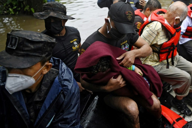 A soldier wraps a child in a blanket during an operation to assist flood victims in Santa Lucia colony in Ilopango, El Salvador, during Tropical Storm Amanda, on May 31, 2020