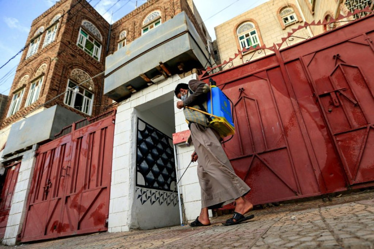 A volunteer in a community-led initiative to prevent the spread of COVID-19 sterilises a street in Yemen's capital Sanaa