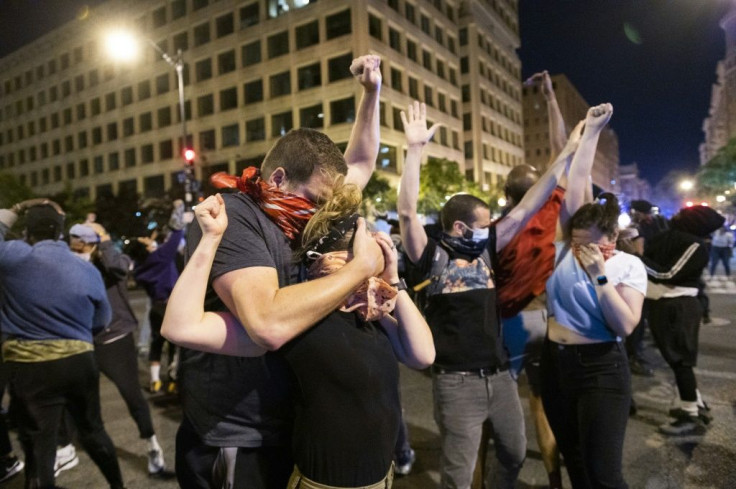 Protesters hold their hands up and try to steady themselves as a military helicopter flies low over a protest in Washington