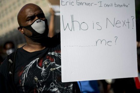 A protestor holds a sign near the White House in Washington, DC, on June 2, 2020. Experts have also warned that racialized violence by police against African Americans is itself a serious health hazard