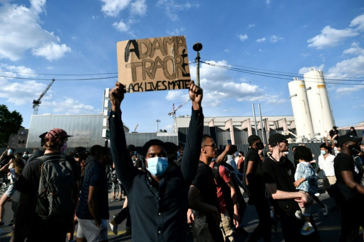 Some 20,000 people protest the 2016 death of a young black man named Adama Traore in French police custody, using slogans echoing those in the demonstrations raging in the US.