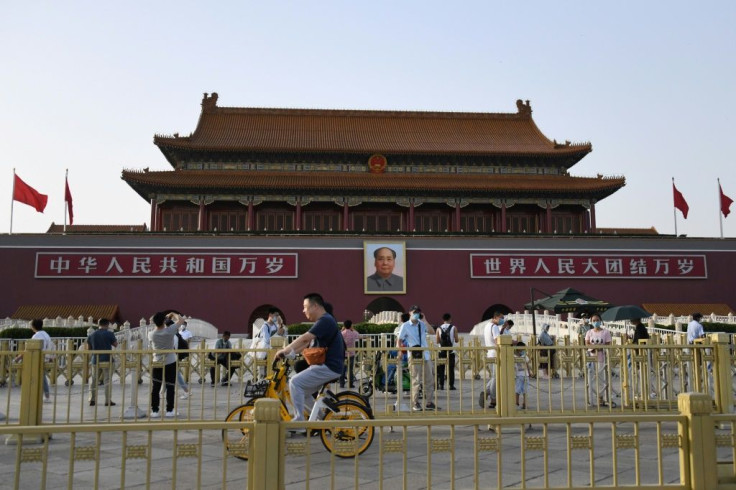 People cycle past Tiananmen gate on the eve of the 31st anniversary of the June 4, 1989 crackdown on pro-democracy protests in Beijing