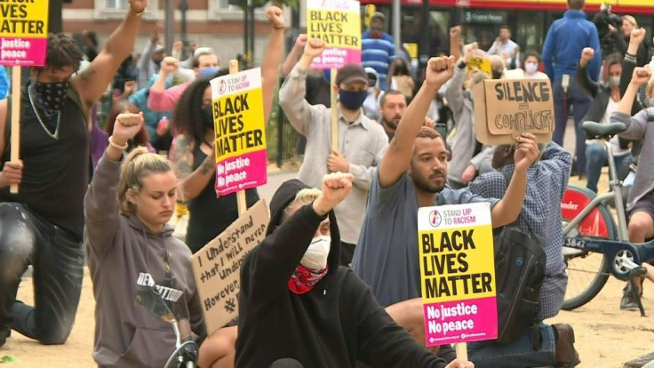 Demonstrators in London take a knee and observe a minute of silence in protest of the killing of George Floyd.