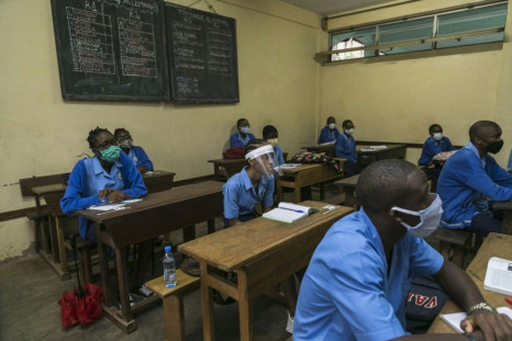 Students at the Jean Tabi high school in Yaounde wear facemasks and visors on the first day back in the classroom