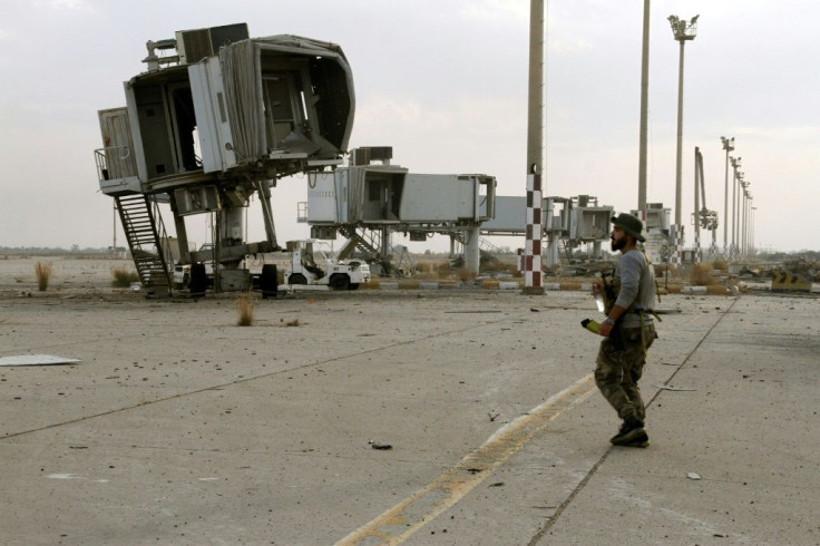 A fighter loyal to Libya's UN-recognised unity government  surveys the abandoned jet bridges at Tripoli's devastated civilian airport following its recapture on Wednesday