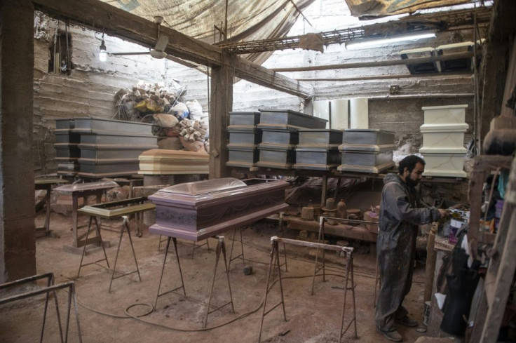 A worker prepares to paint a coffin at a factory in Lima's  Juan de Lurigancho district