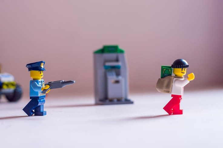 a-lego-police-officer-pointing-his-gun-at-a-robber