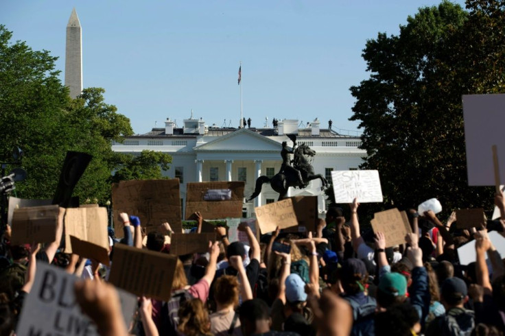 Demonstrators holding signs protest outside the White House over the death of George Floyd