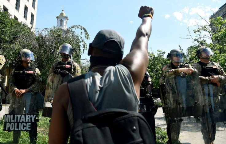 A man kneels in front of military police near the White House to protest the death of George Floyd