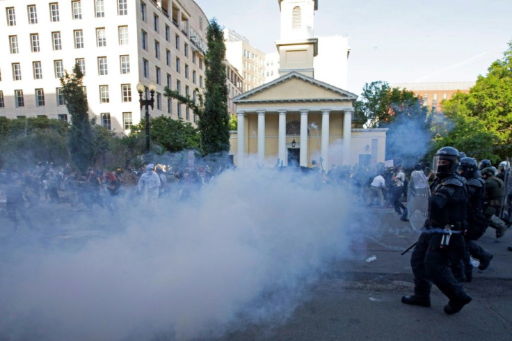 Security personnel wearing riot gear push back demonstrators next to St John's Episcopal Church  outside of the White House