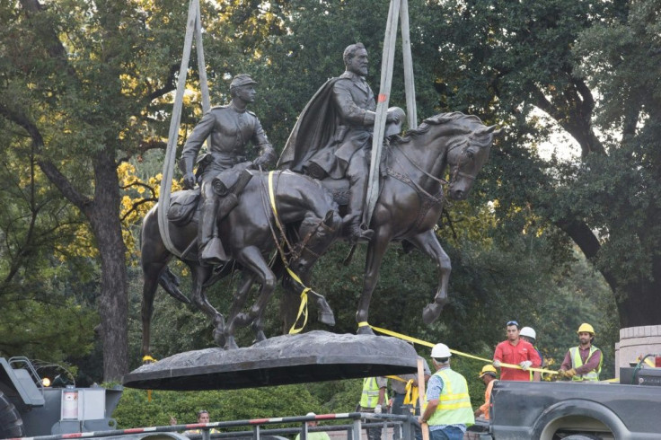 Workers remove statues of Confederate generals from a park in Dallas, Texas, in September 2017