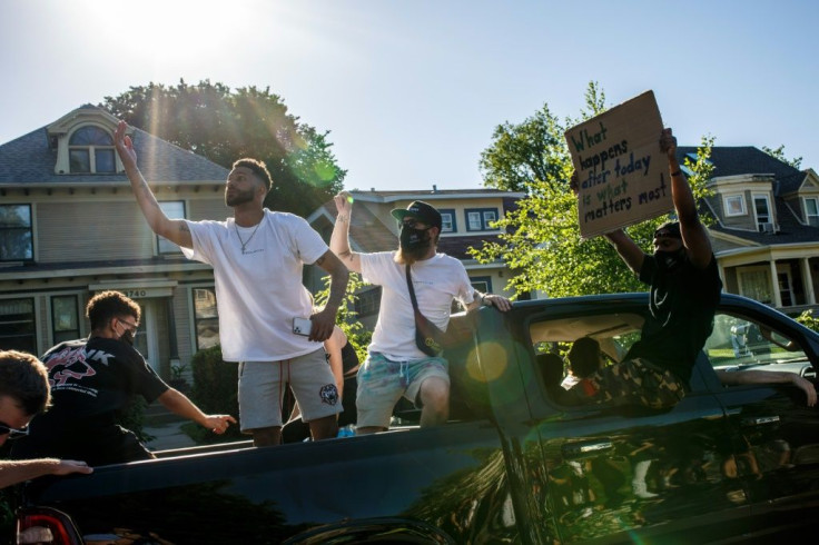 Protesters drive by in a car during a demonstration over the death of George Floyd in Minneapolis, Minnesota