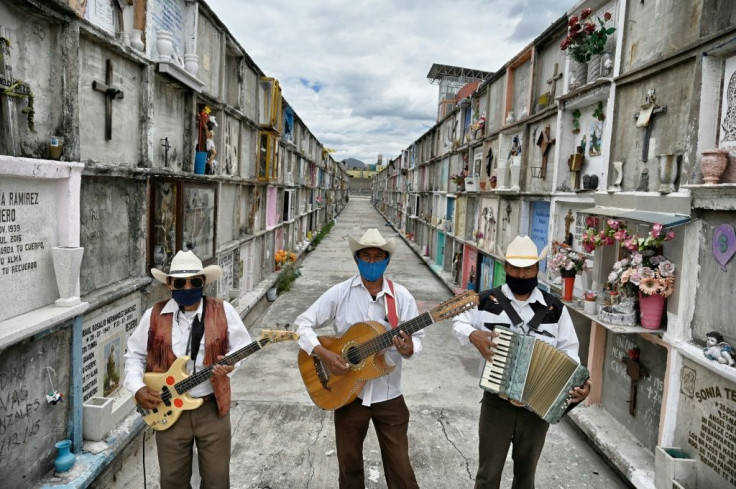 Humberto Montes (C) with musicians Roberto Maldonado (L) and Israel Mundo (R), wait to offer their services before a funeral at the municipal cemetery in Ciudad Nezahualcoyotl on June 3