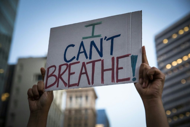 A demonstrator raises a sign during a protest against the death of George Floyd who died on May 25 in Minneapolis whilst in police custody, along a street in Oakland, California on June 3