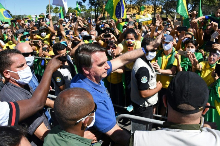 Brazilian President Jair Bolsonaro (C) has opposed lockdown measures