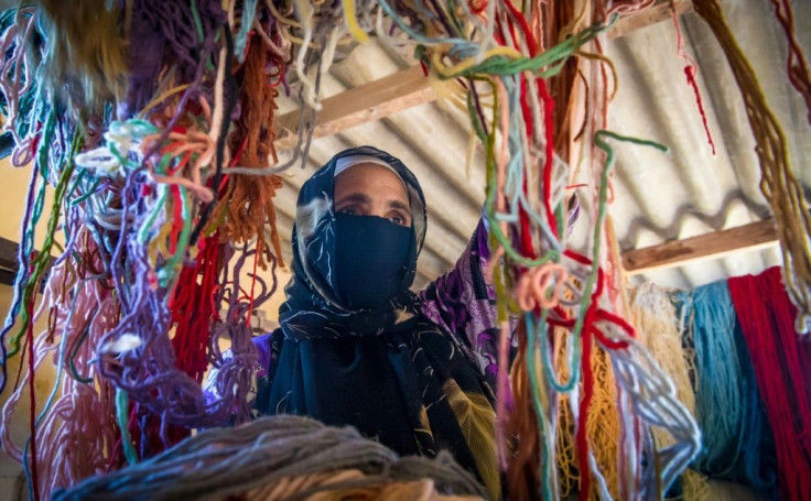 A Moroccan rug weaver sorts through yarn